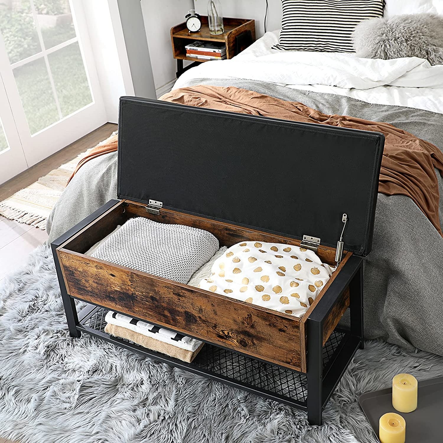 The storage chest at the foot of a bed with linens inside