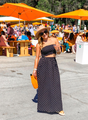 reviewer wearing black set with a summery hat