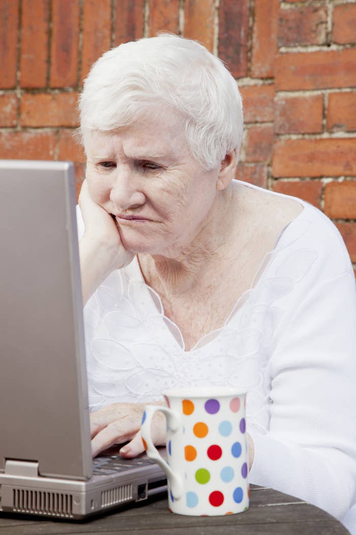 A woman looking at a laptop with a perturbed look on her face