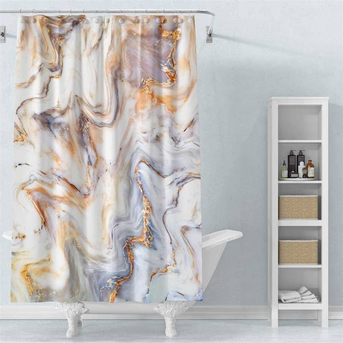 the marble shower curtain hung up over a tub
