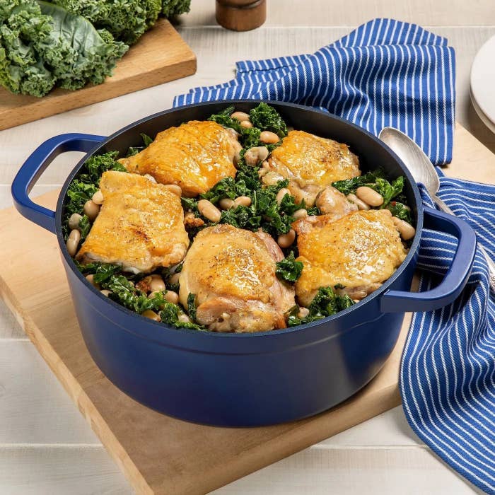 the dutch oven with chicken, greens, and beans inside