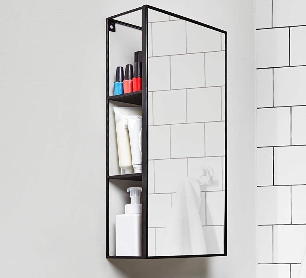 The mirror and cabinet unity in a bathroom with products inside