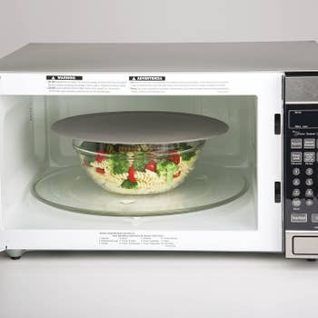 a gray multipurpose mat cover a dish in the microwave