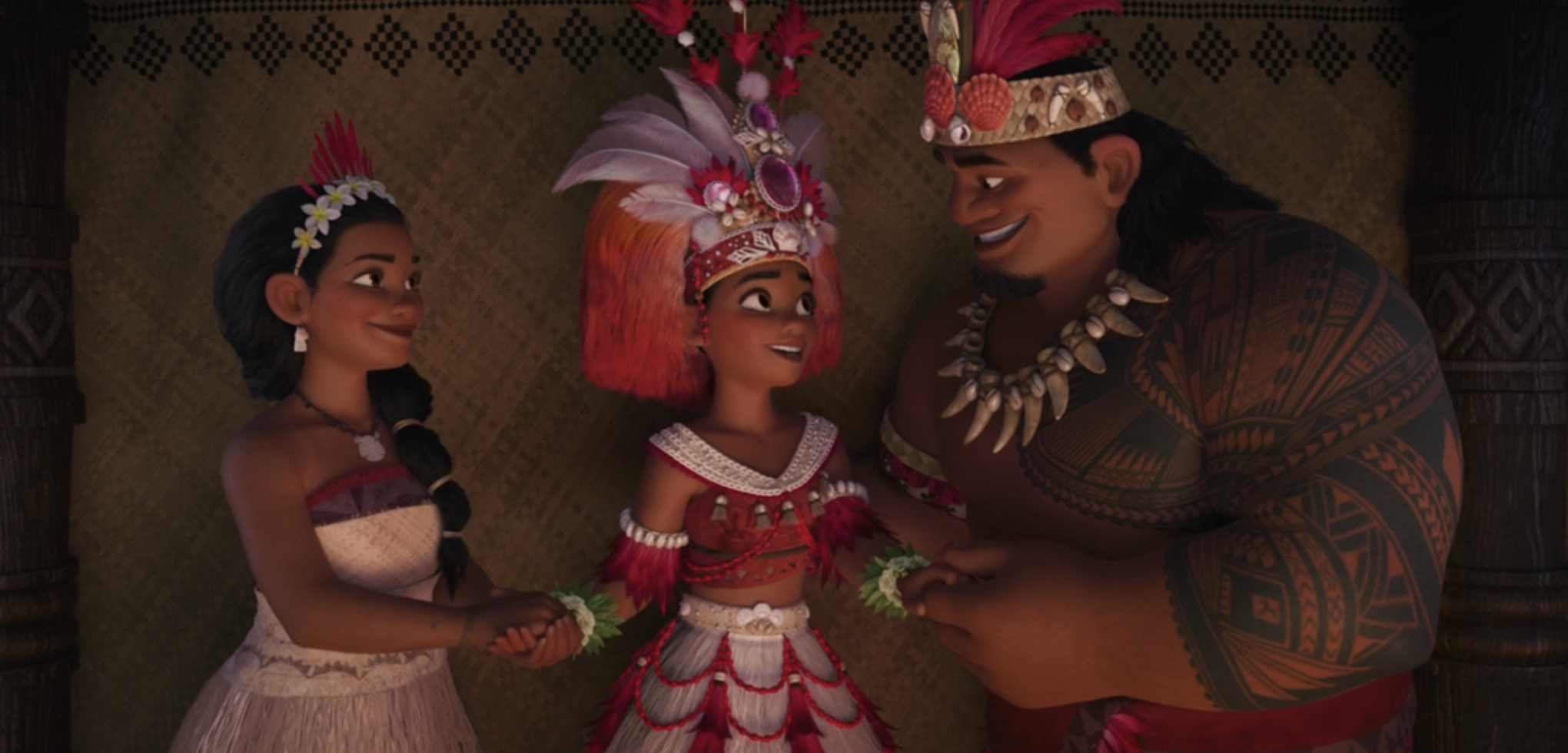 Moana standing with her parents in traditional attire, including a headdress with beads and feathers