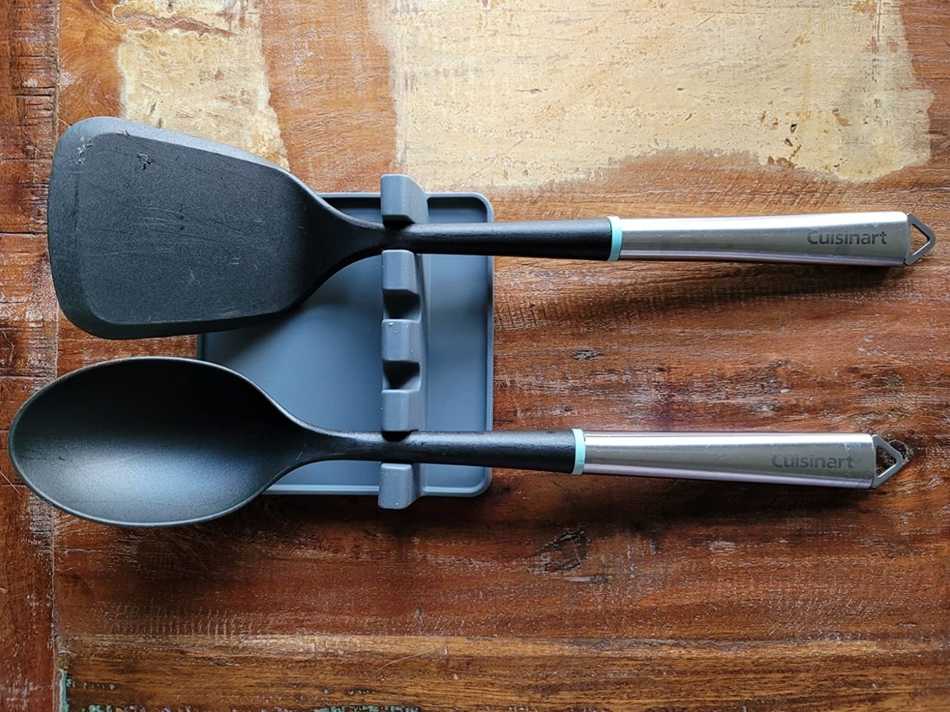 The utensil spoon rest in dark gray holding a spoon and spatula