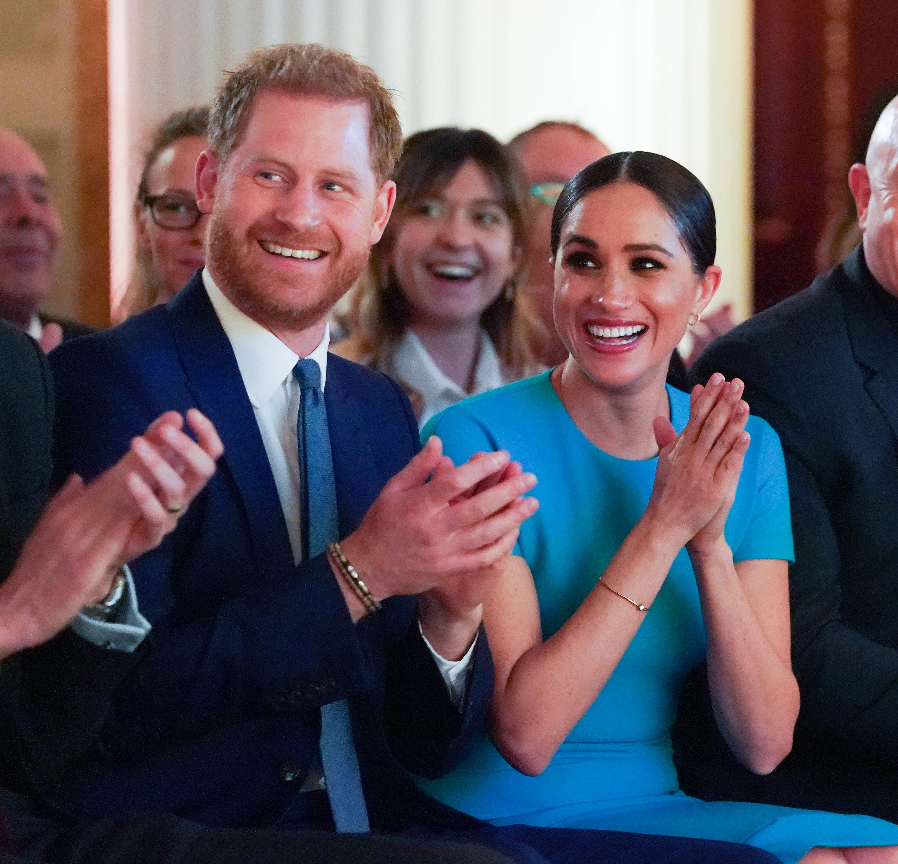 Harry and Meghan applauding and smiling