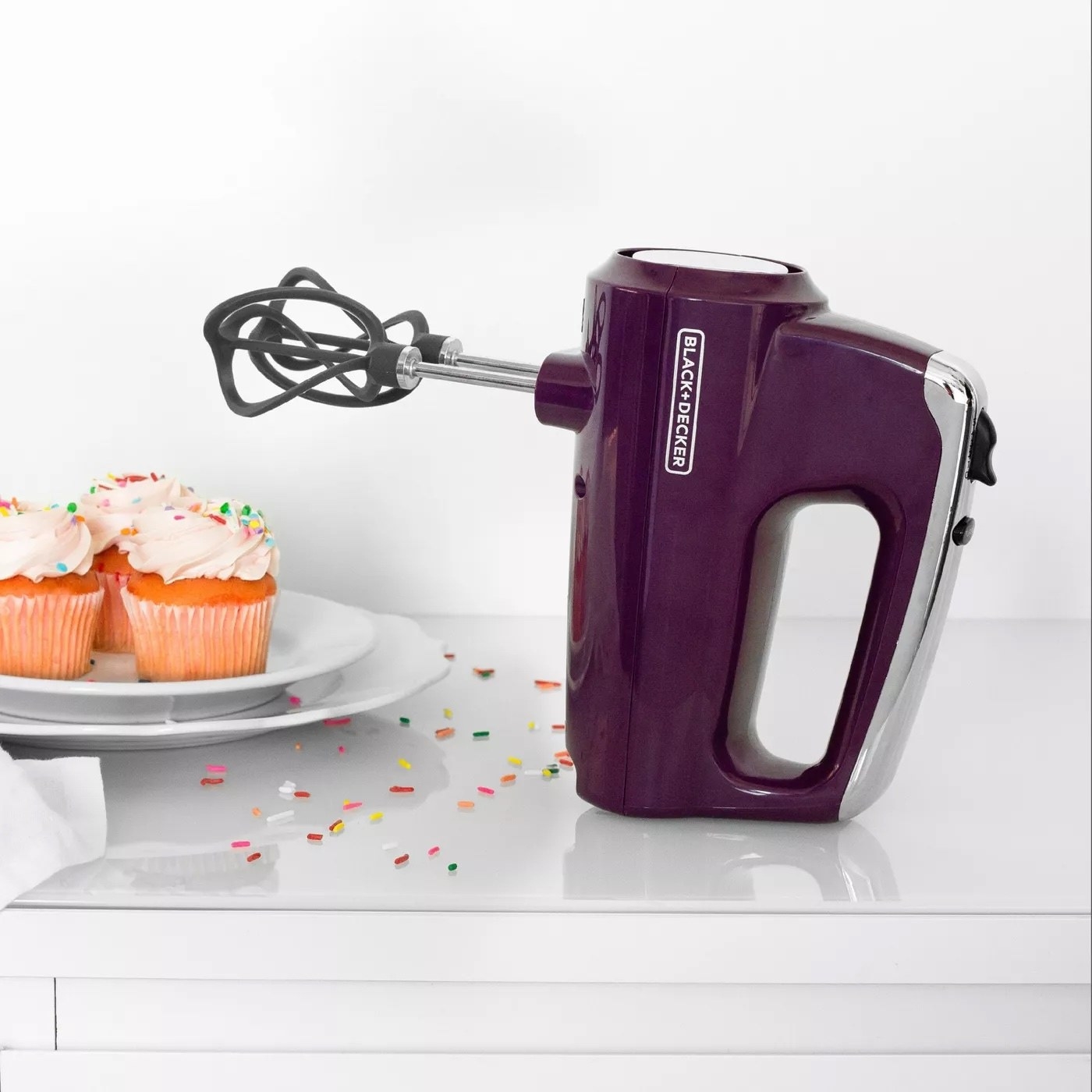 the purple mixer next to cupcakes