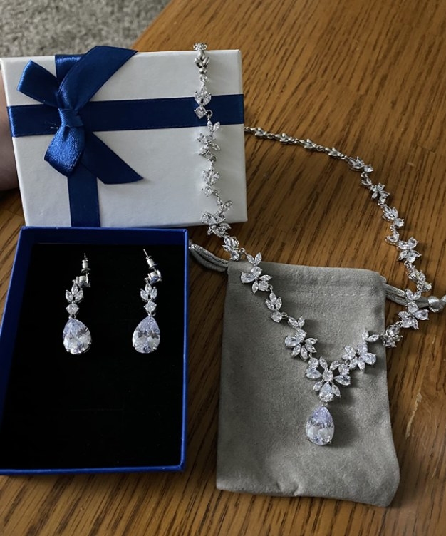 A reviewer showing the necklace and earring set 
