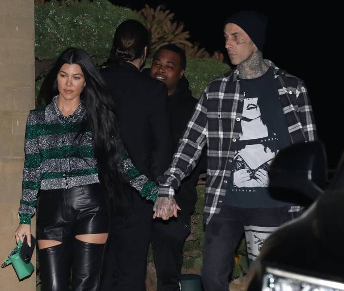 Kourtney and Travis hold hands while leaving a restaurant