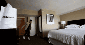gif of someone jumping sideways onto a hotel bed