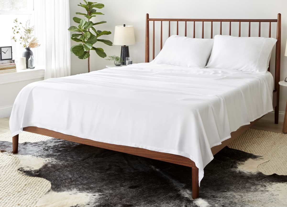 the white arctic aire sheet set on a wooden bed
