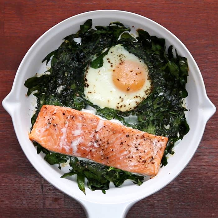 Skillet salmon over spinach with a baked egg.