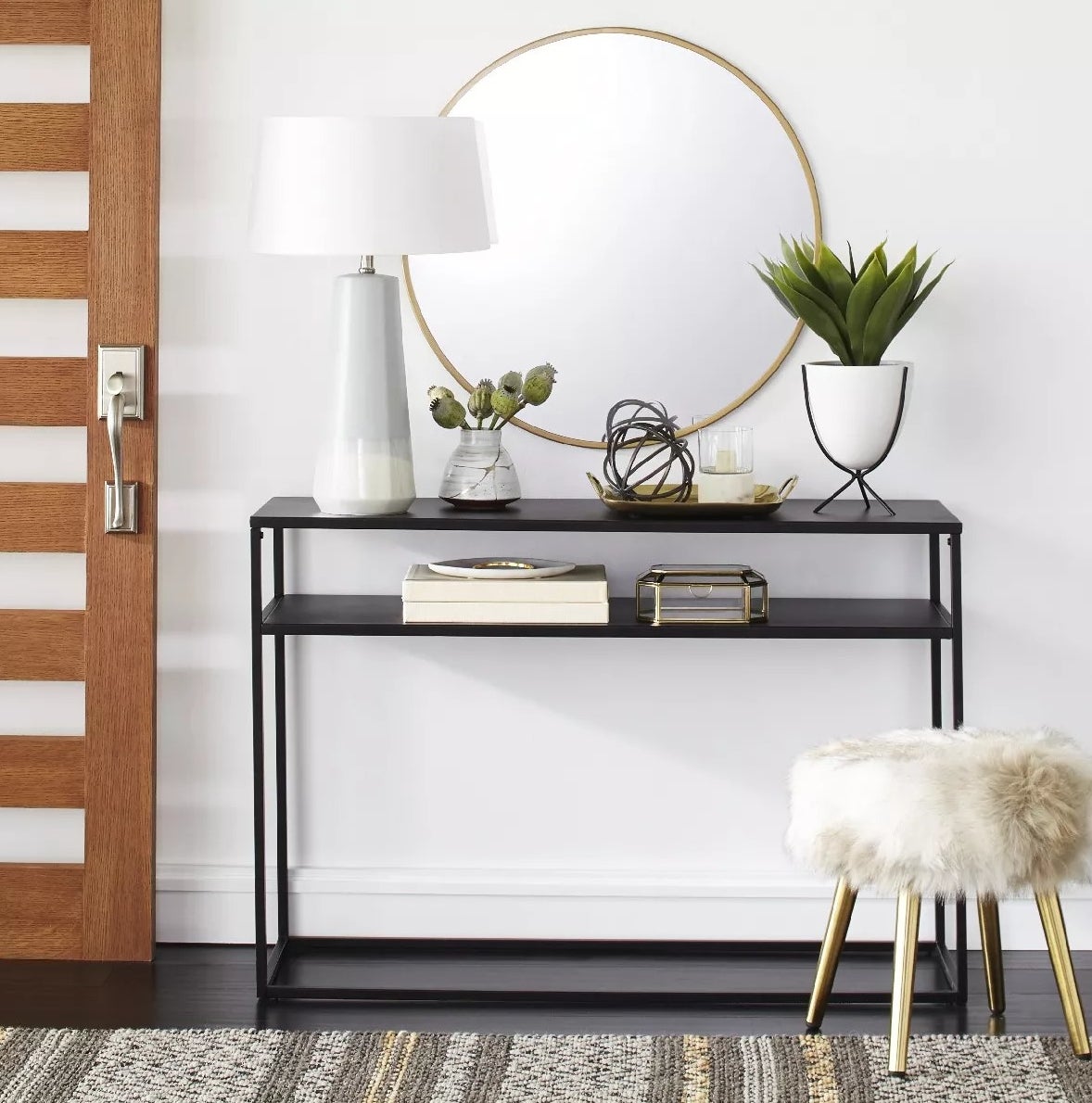 The narrow metal console with two open shelves in an entryway