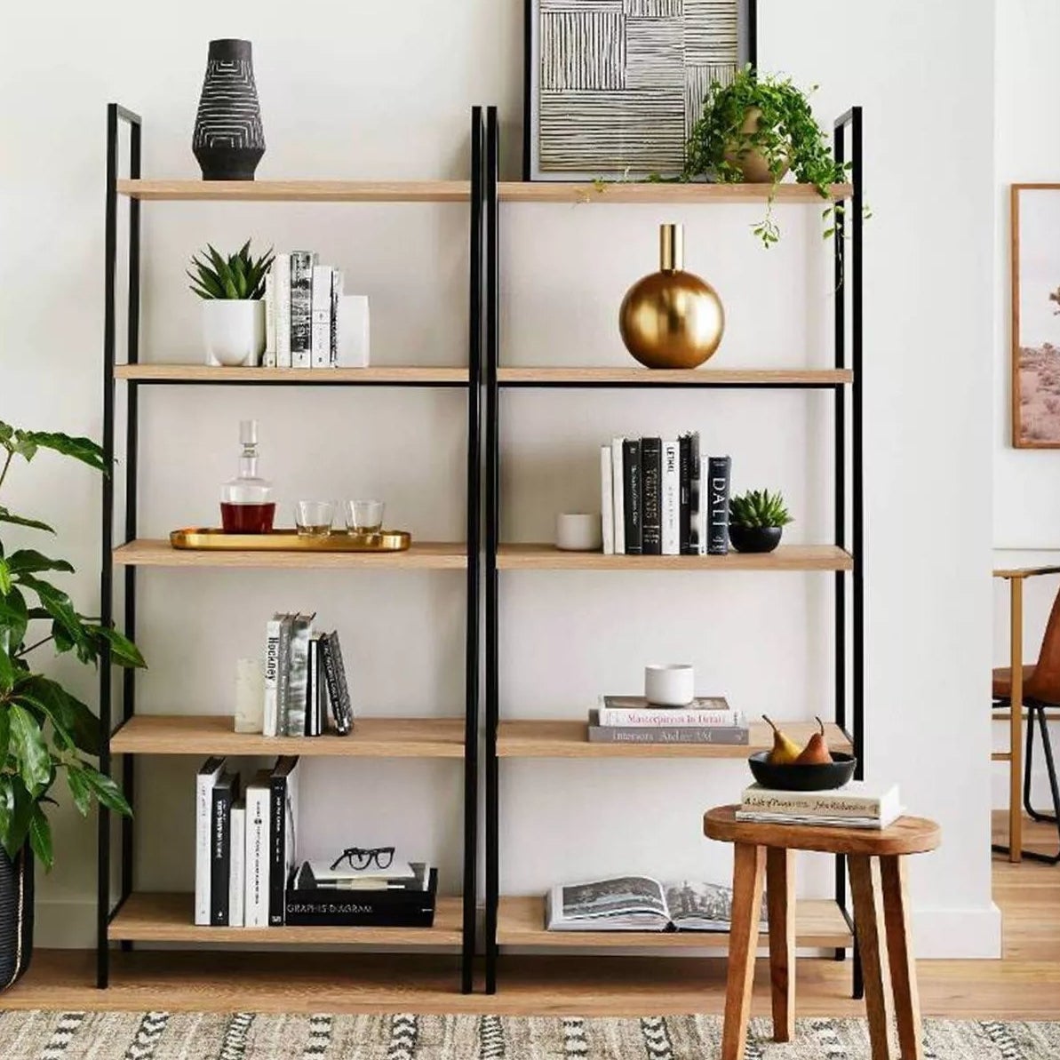 The ladder bookshelf with a metal frame and light wooden shelves in a living room