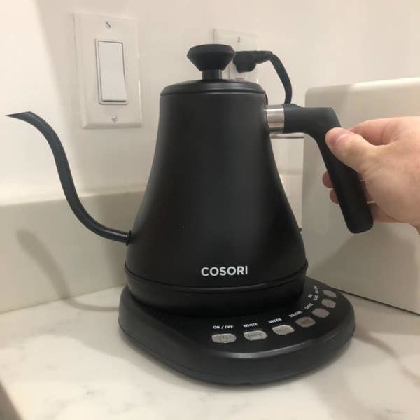 A reviewer holds their black kettle