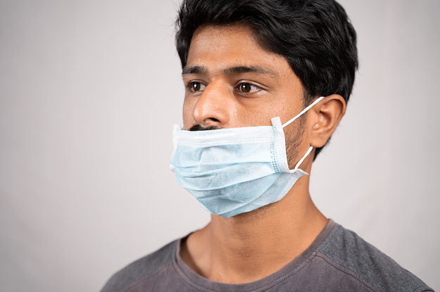 A man wearing a surgical mask incorrectly, below his nose