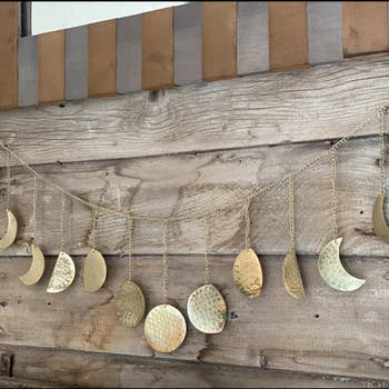 Reviewer's hammered gold garland hangs on a wall