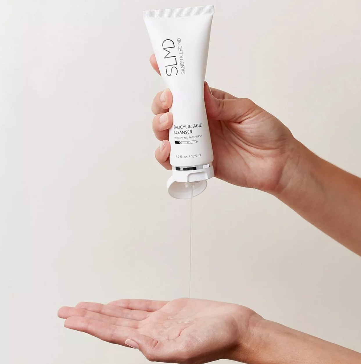 Hand squeezing SLMD cleanser into palm