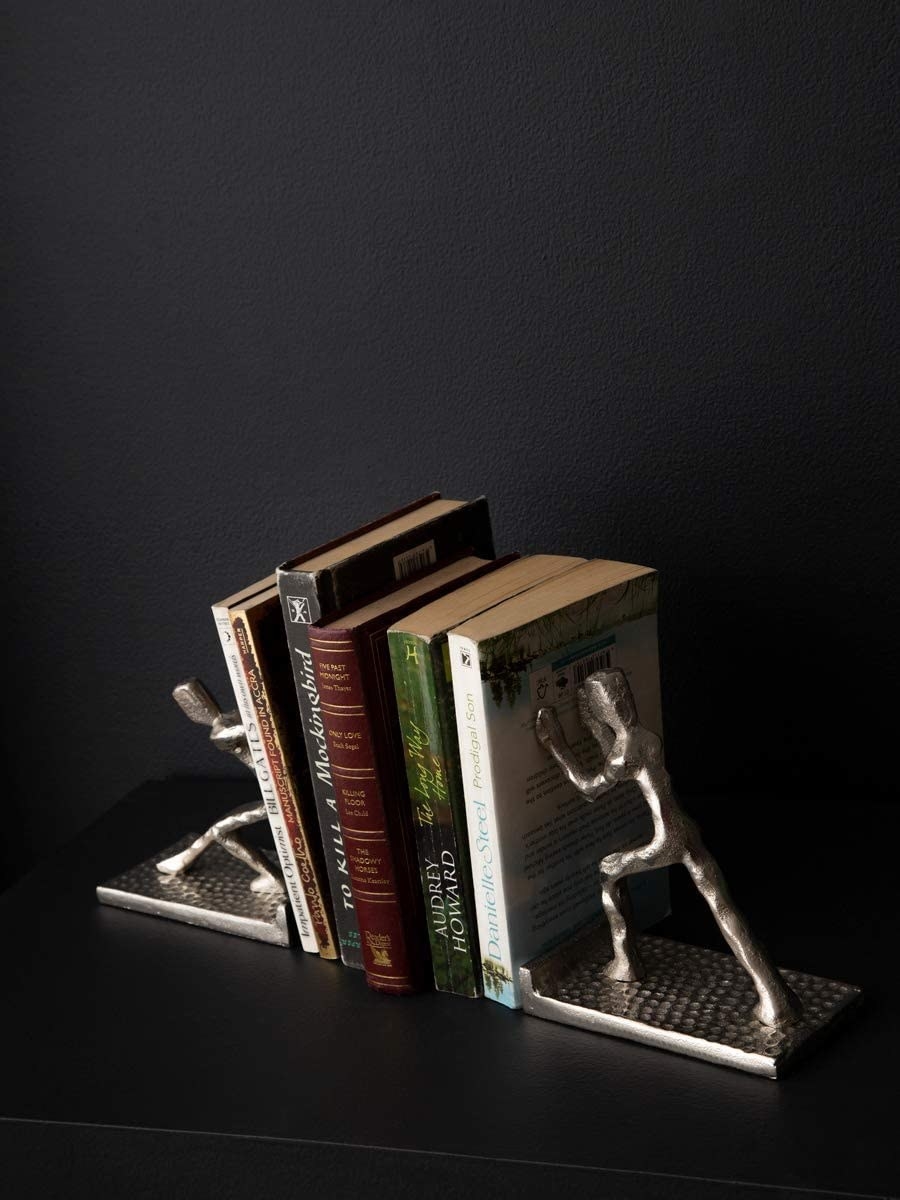 A set of bookends that look like men pushing on each side.