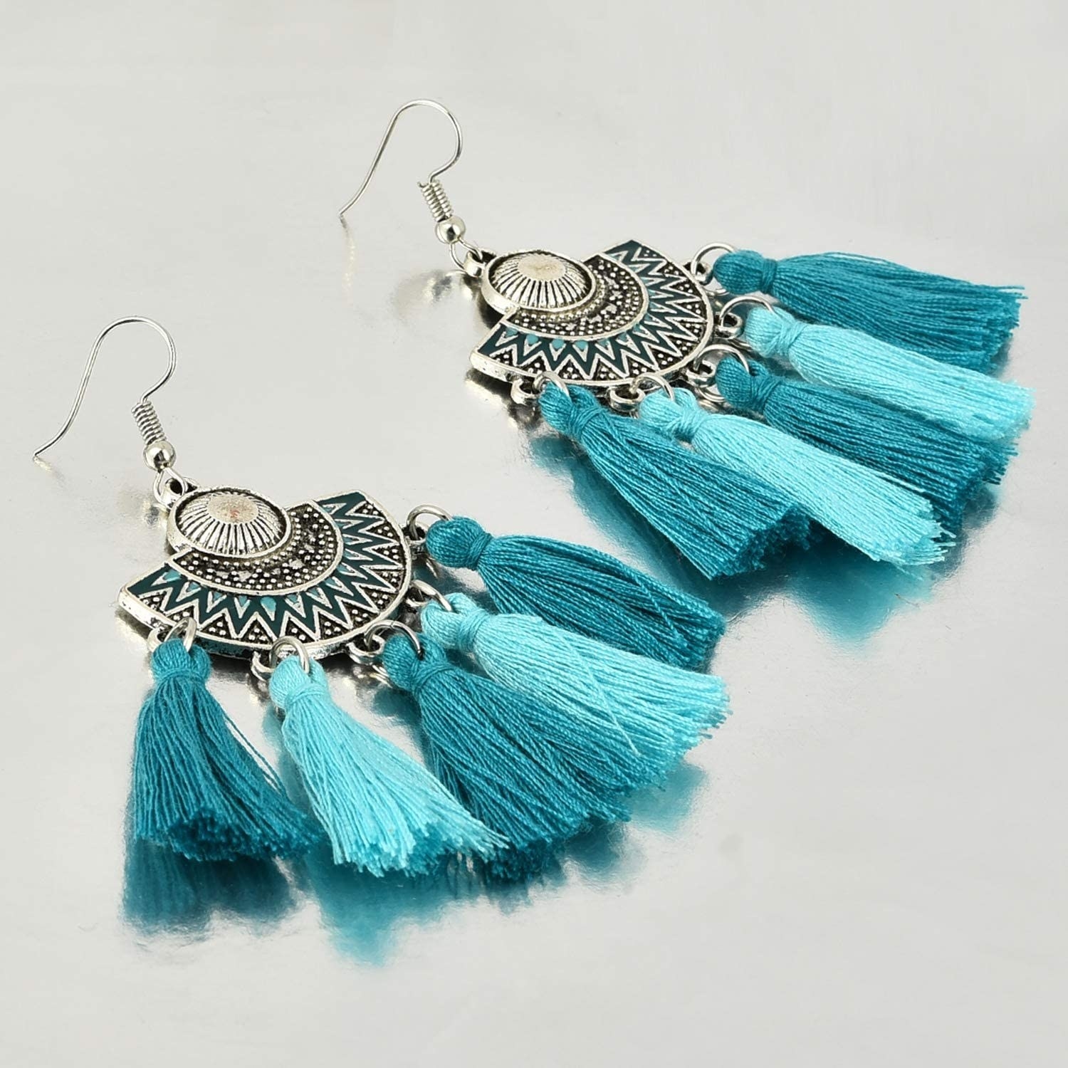 A pair of tasseled earrings in varying shades of blue