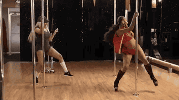 Two women in a pole dancing class