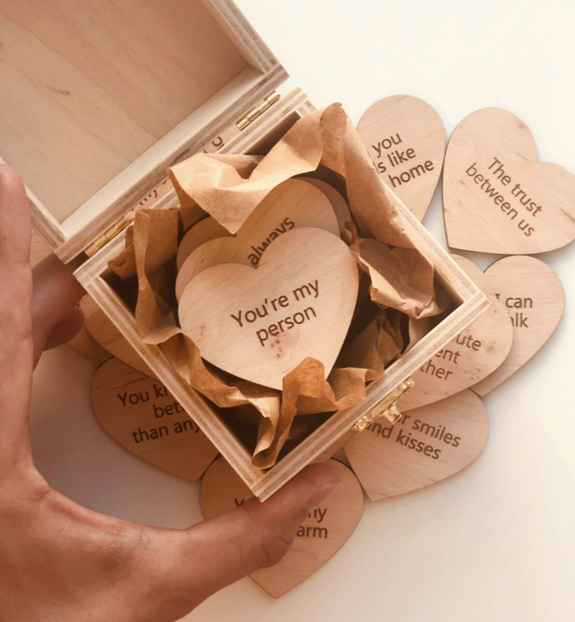 The gift box with heart-shaped wood pieces inside