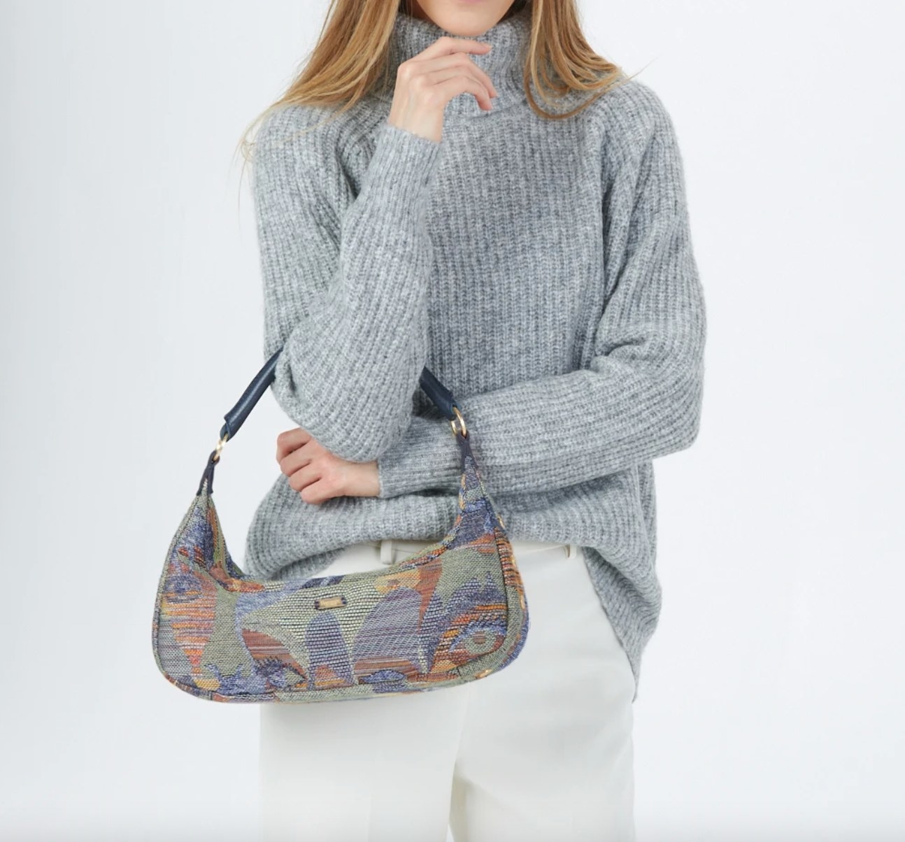 The over the shoulder handbag in gaze/heirloom brushed gold being held by a model