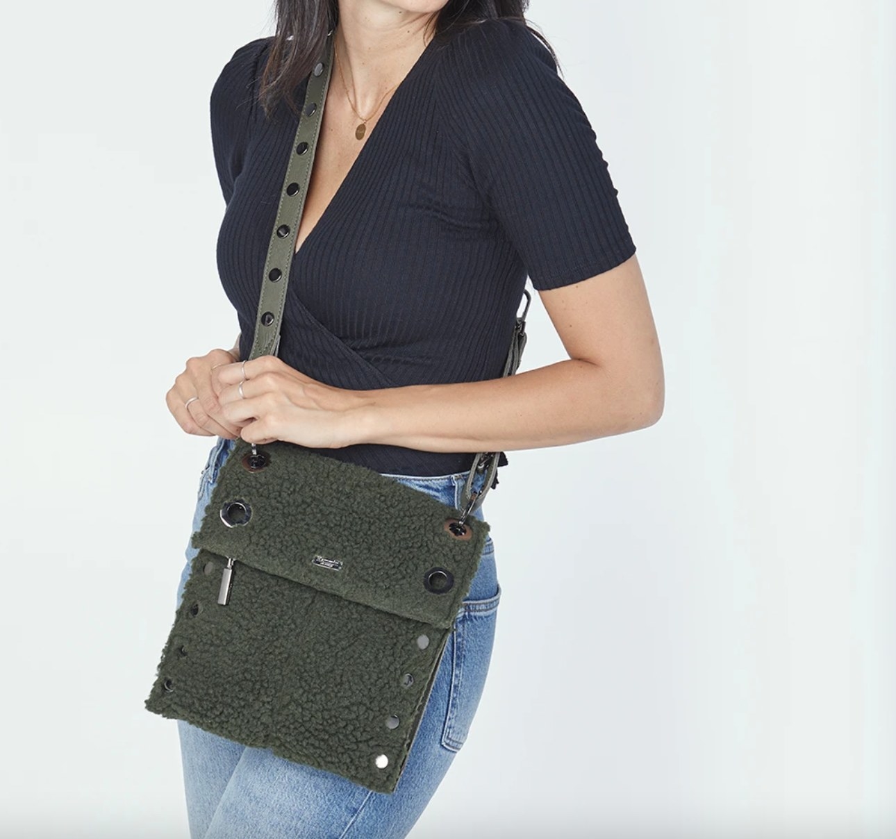 The shearling olive green cross body bag being worn by a model 