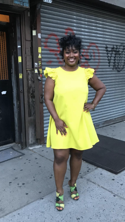 reviewer wearing bright yellow above the knee dress with fluttery cap sleeves