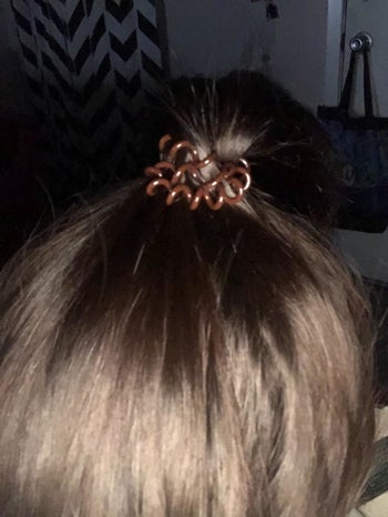 reviewer with the brown version holding their hair in a ponytail