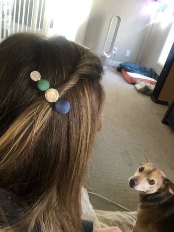 reviewer wearing blue, white, gold and pink clip with round stones