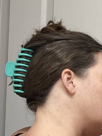 teal clip holding up reviewer's hair