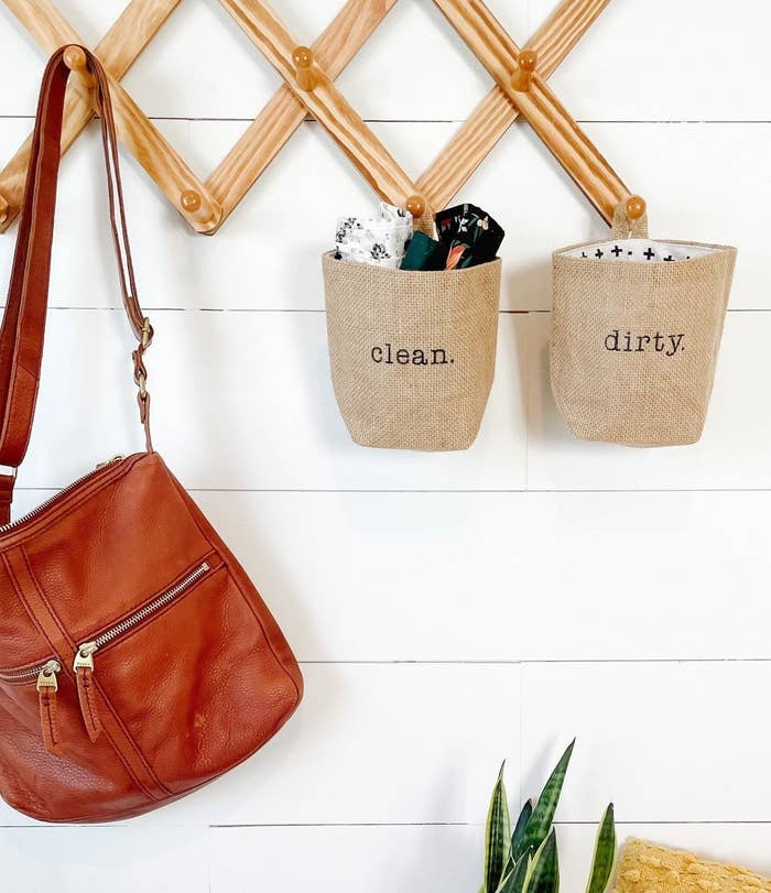 face mask pouches that say "clean" and "dirty" hanging on wall hooks