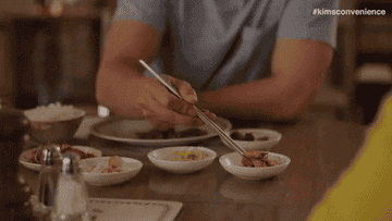 Simu Liu from the show &quot;Kim&#x27;s Convenience&quot; eating Korean side dishes with chopsticks