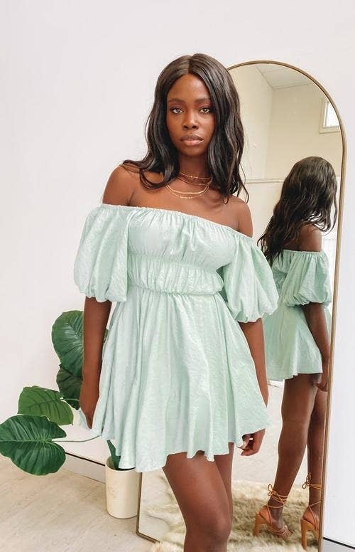 A model wearing the off-the-shoulder dress in a pastel-mint color