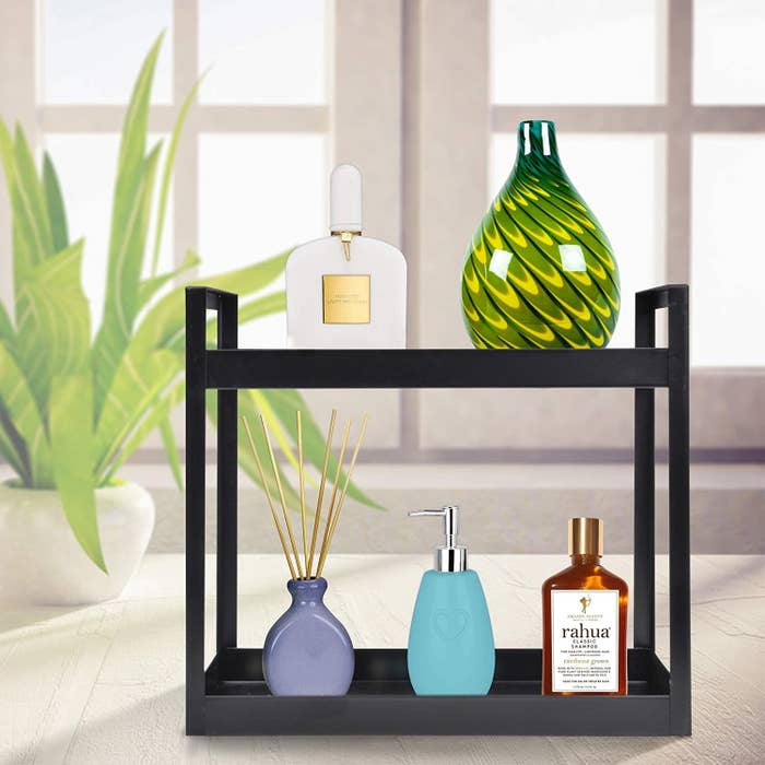 A black, metal two-tier shelf with items on it 