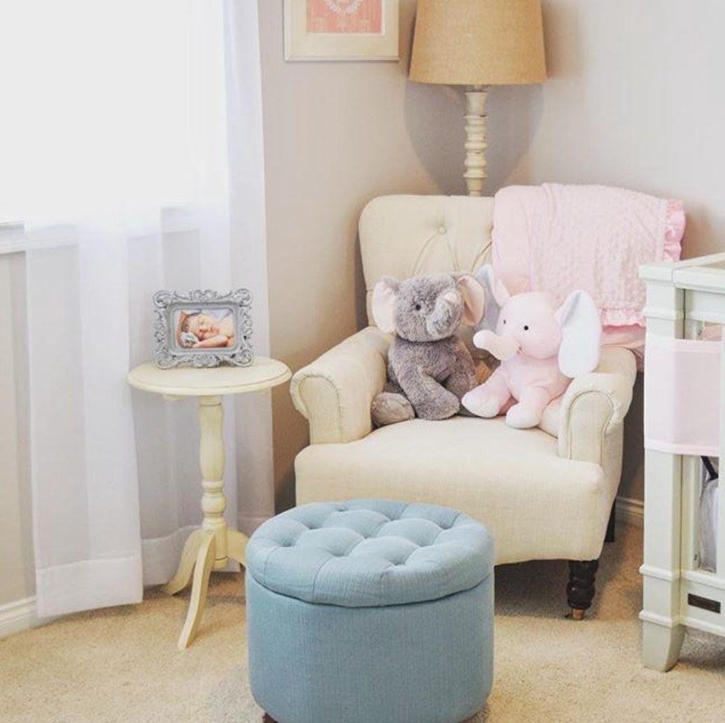 A light blue tufted storage ottoman with wooden legs