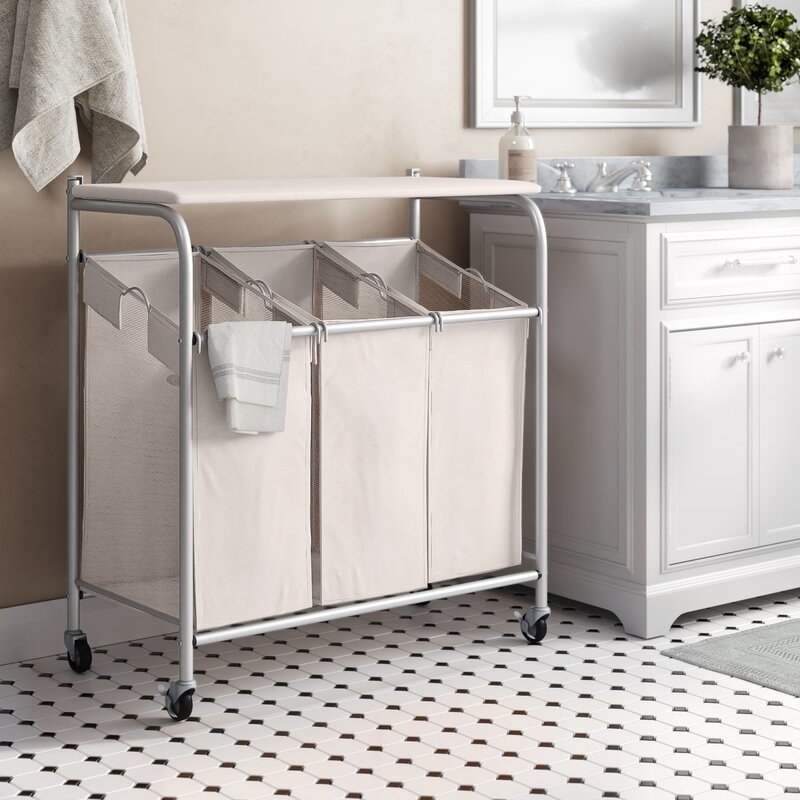 The three-basket, wheeled laundry hamper in a bathroom 