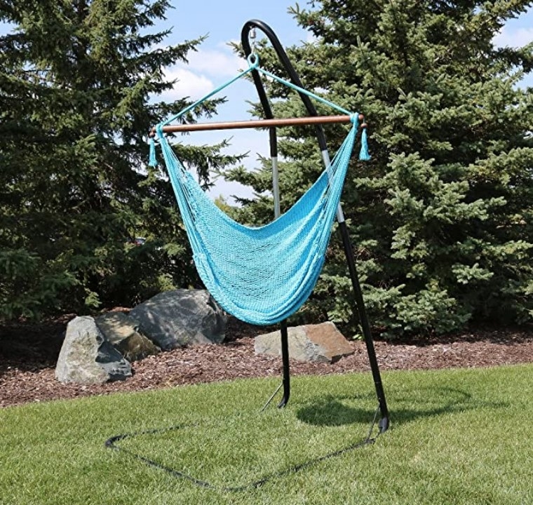 A blue, hanging hammock on a stand outside