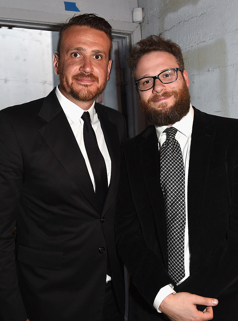 Jason and Seth, both wearing suits, standing close together