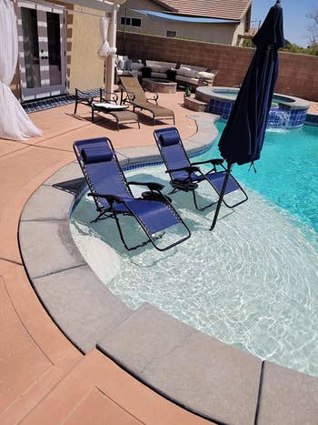 a reviewer's blue lounge chairs in a pool