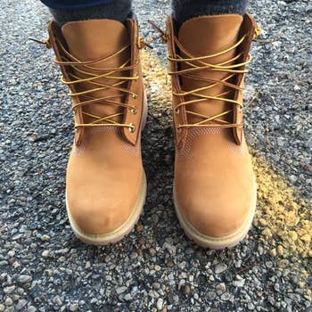 reviewer in the taupe lace-up high-top leather boots with lug soles and woven laces