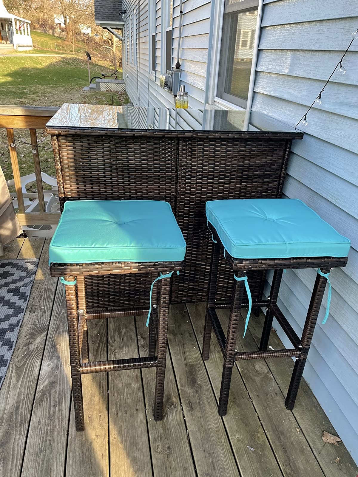 a reviewer's bar set with teal cushions on the stools