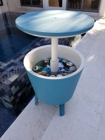 a reviewer's teal table/cooler holding soda cans