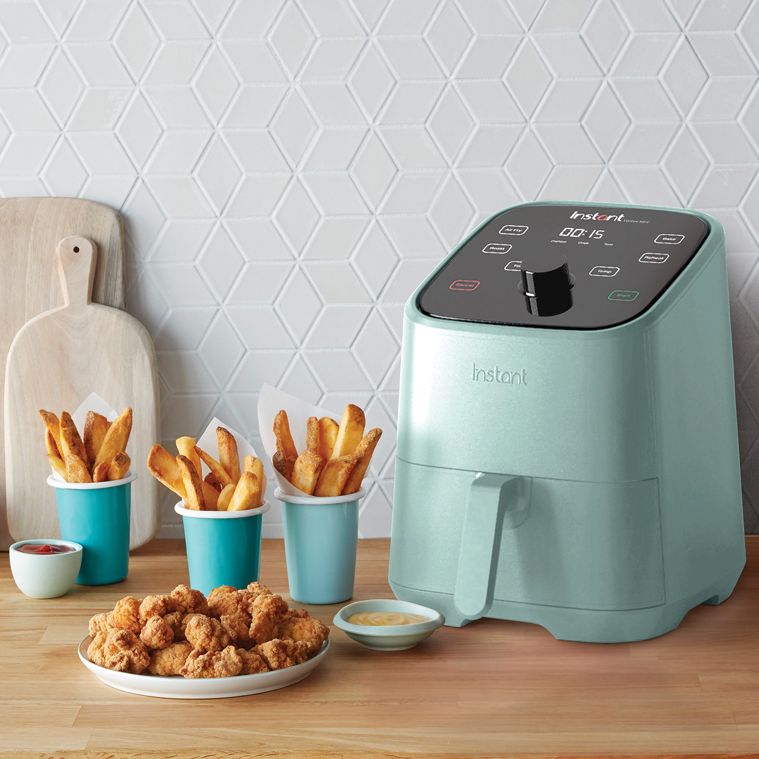 the light blue air fryer next to fries and chicken tenders