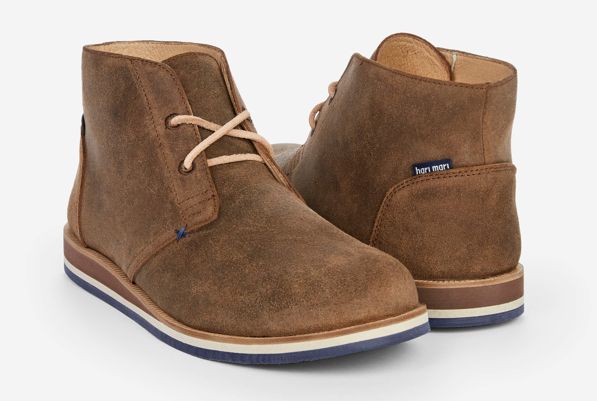 Two brown lace-up chukka boots with blue soles