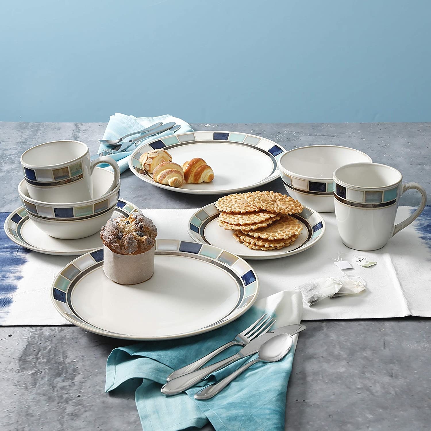the white and blue Gibson Elite Casa Blanca Round Reactive Glaze Stoneware laid out on a table with biscuits and croissants on the plates