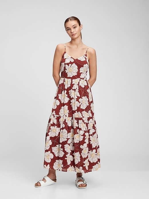 a person wearing a floral, maxi dress with spaghetti straps