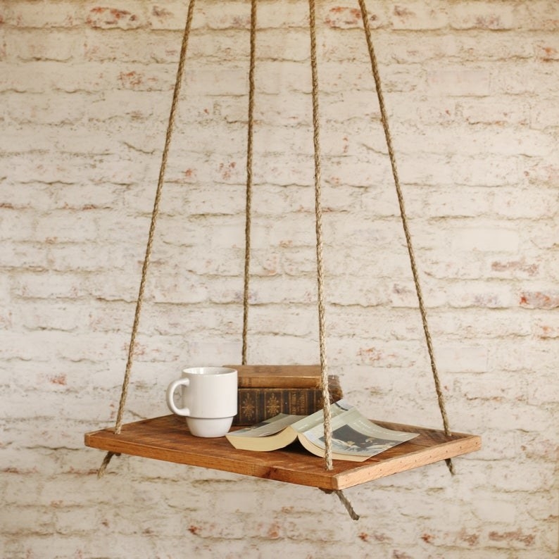 Hanging shelf with coffee cup and book on top of it