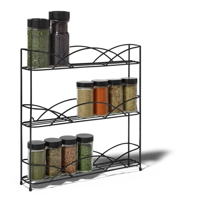 the wire spice rack with unlabeled spice bottles on it